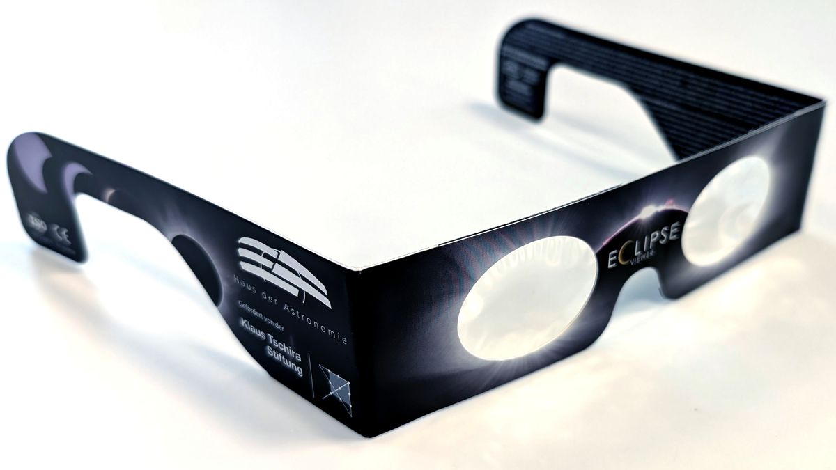 Lunettes d'éclipse en carton, vues de trois quarts sur fond blanc. Sur la branche gauche sont imprimés le logo ISO et le sigle CE.